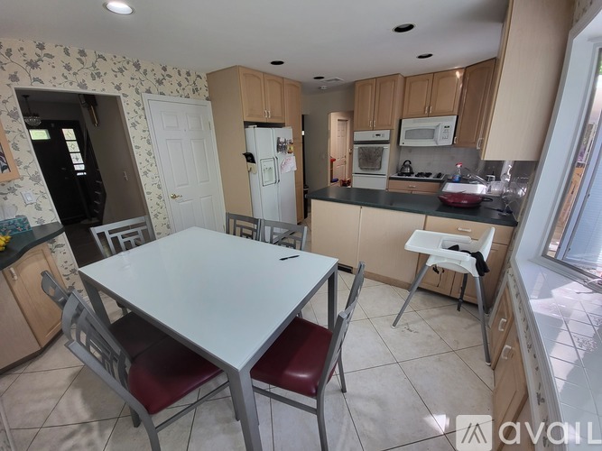 A kitchen with a table and chairs in the foreground.