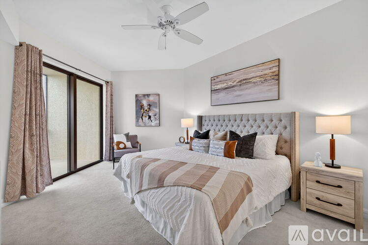 A bedroom with a large bed and a ceiling fan.