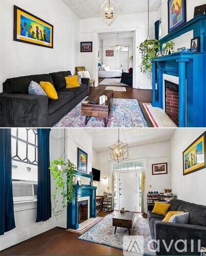 A living room with a blue fireplace and a grey couch.