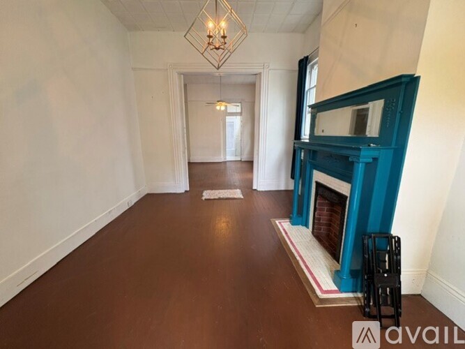 A hallway with a blue fireplace and a white door at the end.