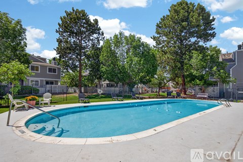 A swimming pool surrounded by trees and a fence.