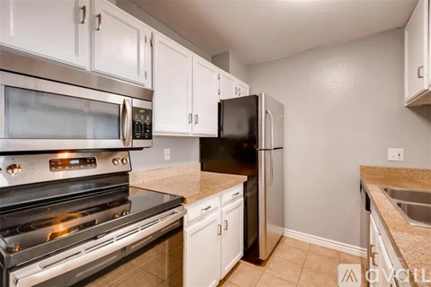 A kitchen with white cabinets and stainless steel appliances.