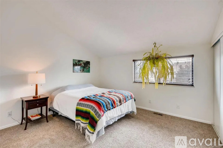 A bedroom with a bed, a lamp, and a picture on the wall.