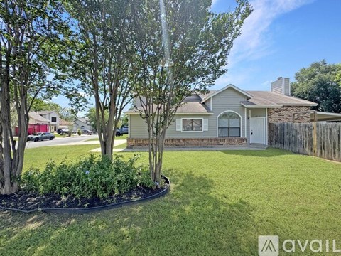 A house with a well-maintained lawn and a fence in the background.
