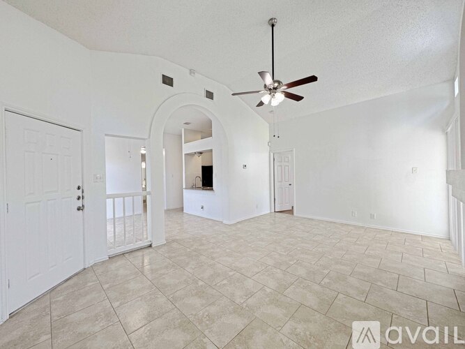 A spacious room with a ceiling fan and tiled flooring.