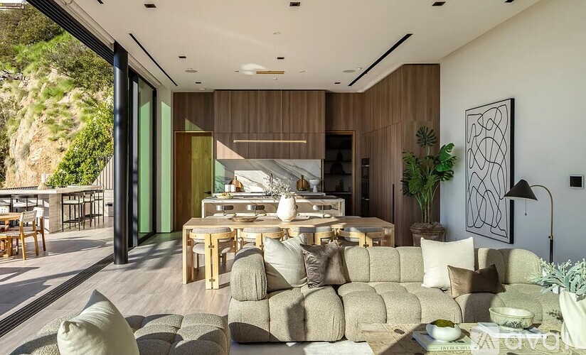A modern living room with a large couch and a dining table.