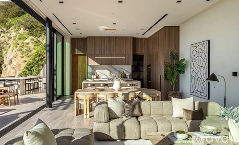 A modern living room with a large couch and a dining table.