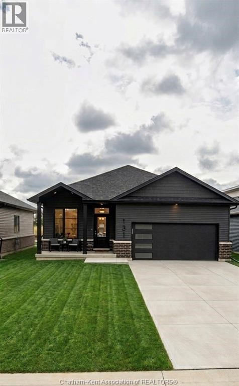 A modern house with a black roof and a garage door.