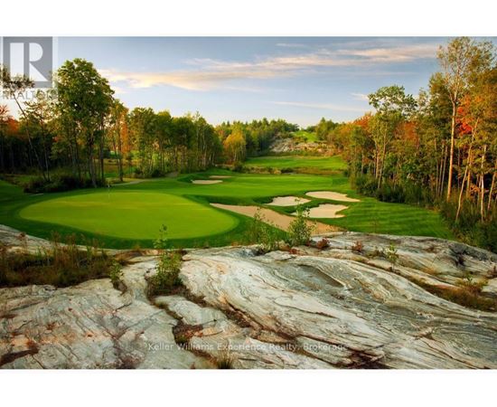A golf course with a large rock formation in the foreground.