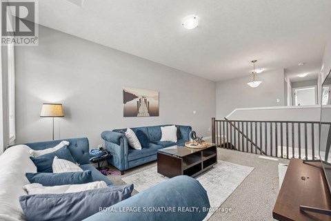 A living room with a blue couch and a painting on the wall.