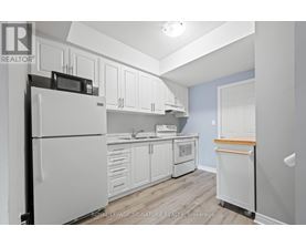 A kitchen with white cabinets and appliances.