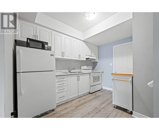 A kitchen with white cabinets and appliances.