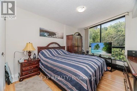 A bedroom with a bed, dresser, and a painting on the wall.