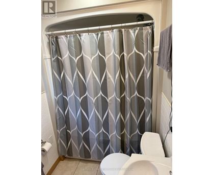 A shower curtain with a grey and white diamond pattern.