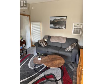 A grey couch with a pillow and a blanket on it.