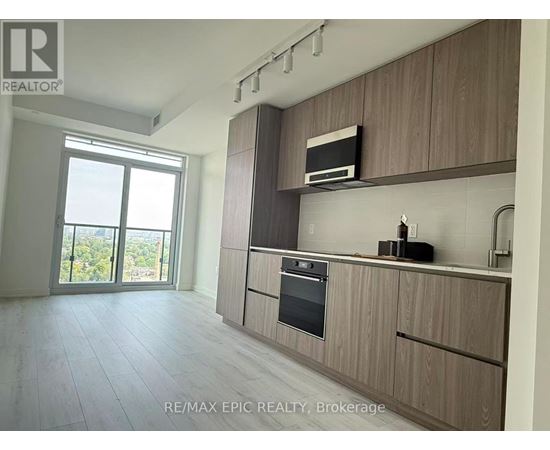 A modern kitchen with wooden cabinets and a stainless steel oven.