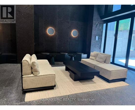A modern living room with a beige sofa and a black coffee table.