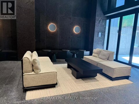 A modern living room with a beige sofa and a black coffee table.