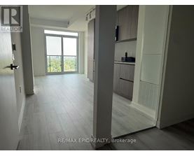 A spacious room with a sliding glass door leading to a balcony.