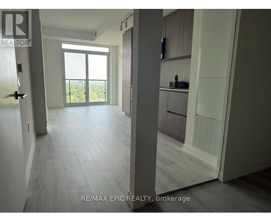 A spacious room with a sliding glass door leading to a balcony.