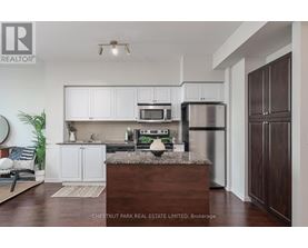 A kitchen with white cabinets and a wooden island.
