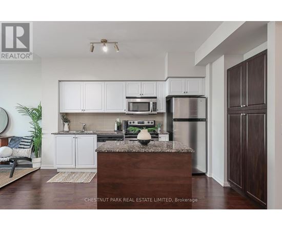 A kitchen with white cabinets and a wooden island.
