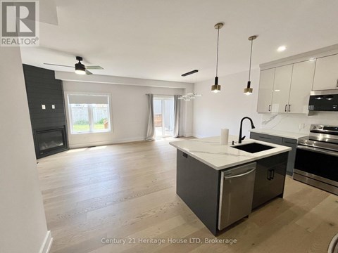 A spacious kitchen with a modern design featuring a stainless steel dishwasher and a white countertop.