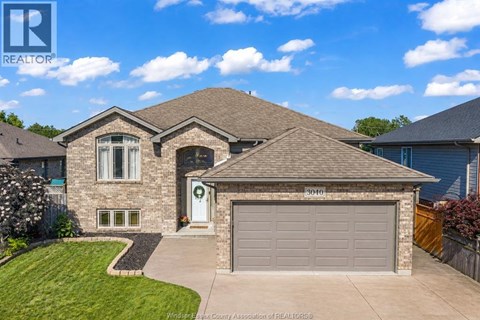 A house with a garage and a driveway in front of it.
