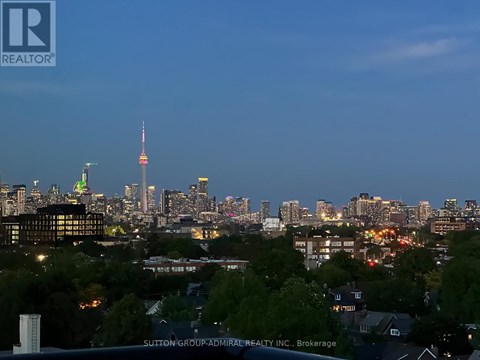 A cityscape at dusk with the skyline illuminated by city lights.