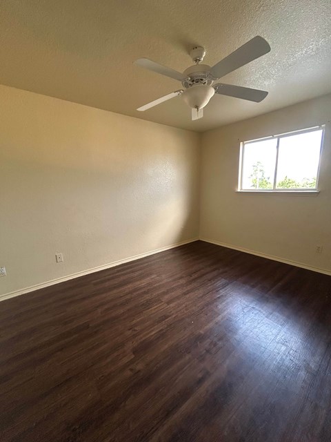 A room with a ceiling fan and a window.