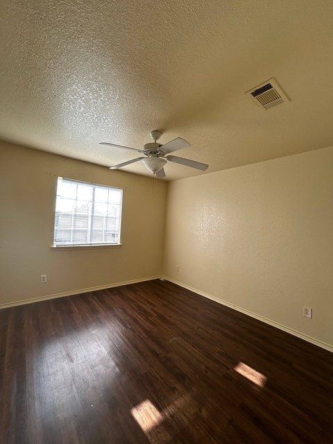 A room with a ceiling fan and a window.
