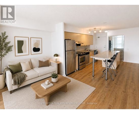 A living room with a couch, coffee table, and kitchen area.