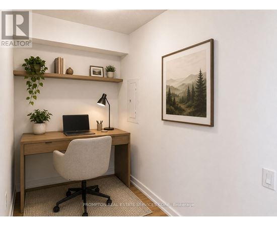A home office with a desk, chair, and a painting on the wall.