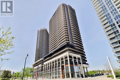 A tall building with a curved facade stands in front of two other buildings.