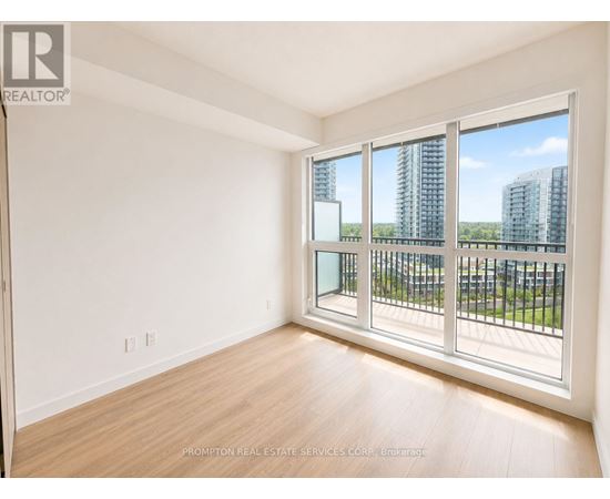 A room with a large window and wooden flooring.