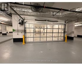 A large garage door in a building with Prompton Real Estate Services Corp. on the wall.