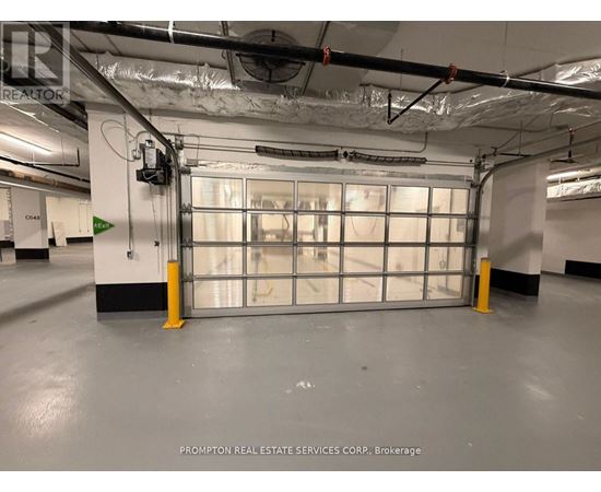 A large garage door in a building with Prompton Real Estate Services Corp. on the wall.