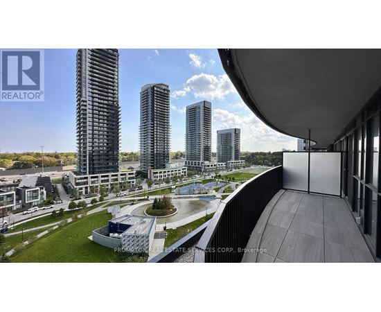 A modern building complex with a pool in the foreground and high-rise buildings in the background.