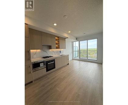 A kitchen with wooden cabinets and a marble backsplash.