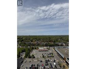 A parking lot with cars and a building in the background.