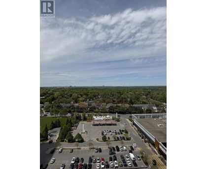 A parking lot with cars and a building in the background.