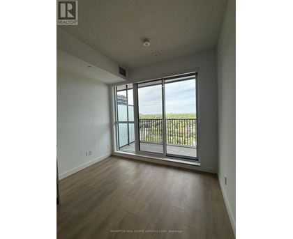 A room with a sliding glass door leading to a balcony.