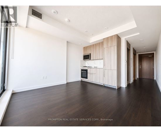 A spacious room with wooden floors and white walls.