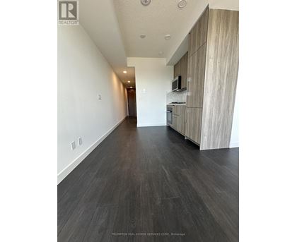 A long hallway with wood floors and white walls.