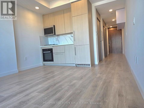 A kitchen with wooden floors and cabinets.