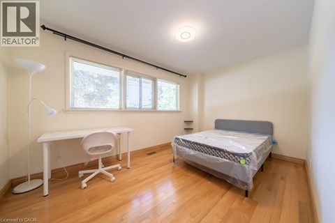 A bedroom with a bed, desk, and chair.