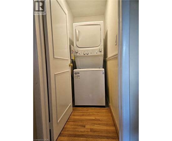 A white dishwasher is in a narrow hallway.