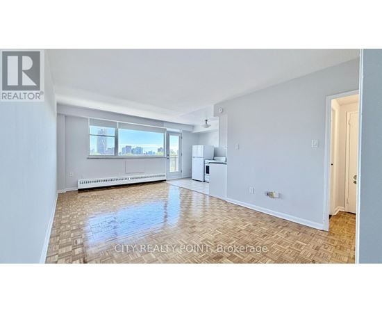 A kitchen with white cabinets and a wooden floor.