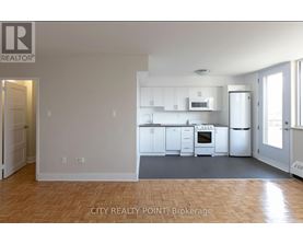 A realtor logo is on the top left of a photo of a kitchen.