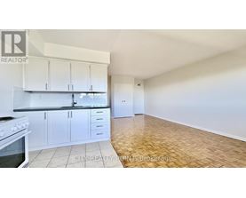 A kitchen with white cabinets and a stove top oven.